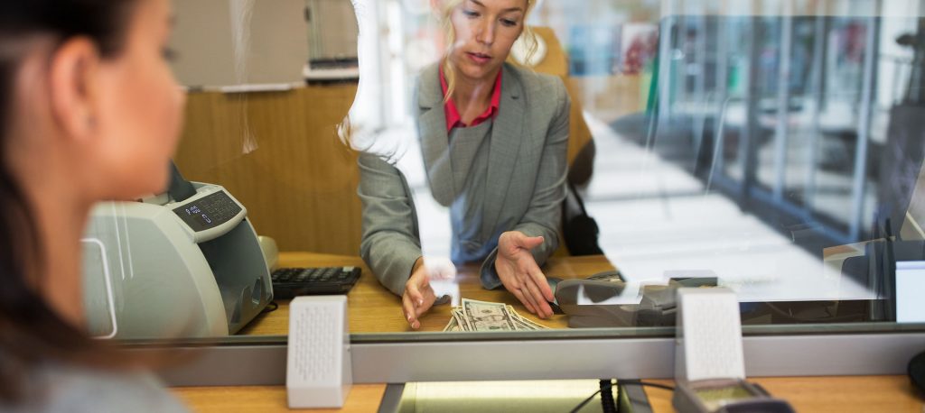 Bank teller with a currency counter.