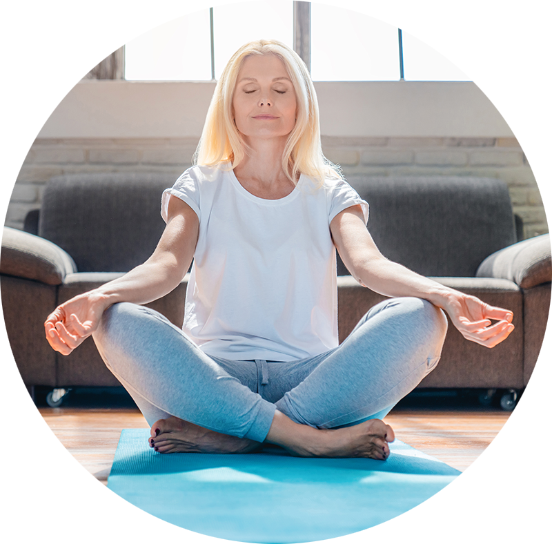 the same woman meditating on a yoga mat.